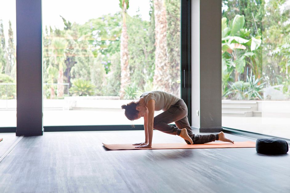 Femme faisant de l'exercice sur un tapis de yoga à l'hôtel Sha Wellness Clinic.