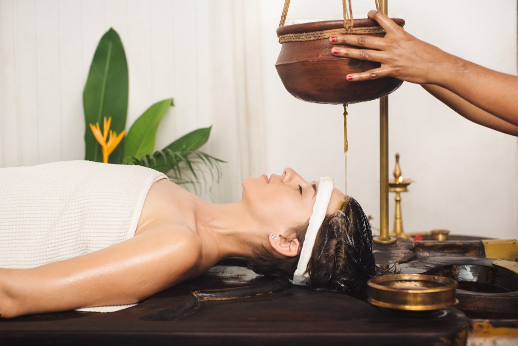 Ayurveda et perte de cheveux - coulée d'huile sur le front, l'huile coule également sur les cheveux, ce qui les soigne