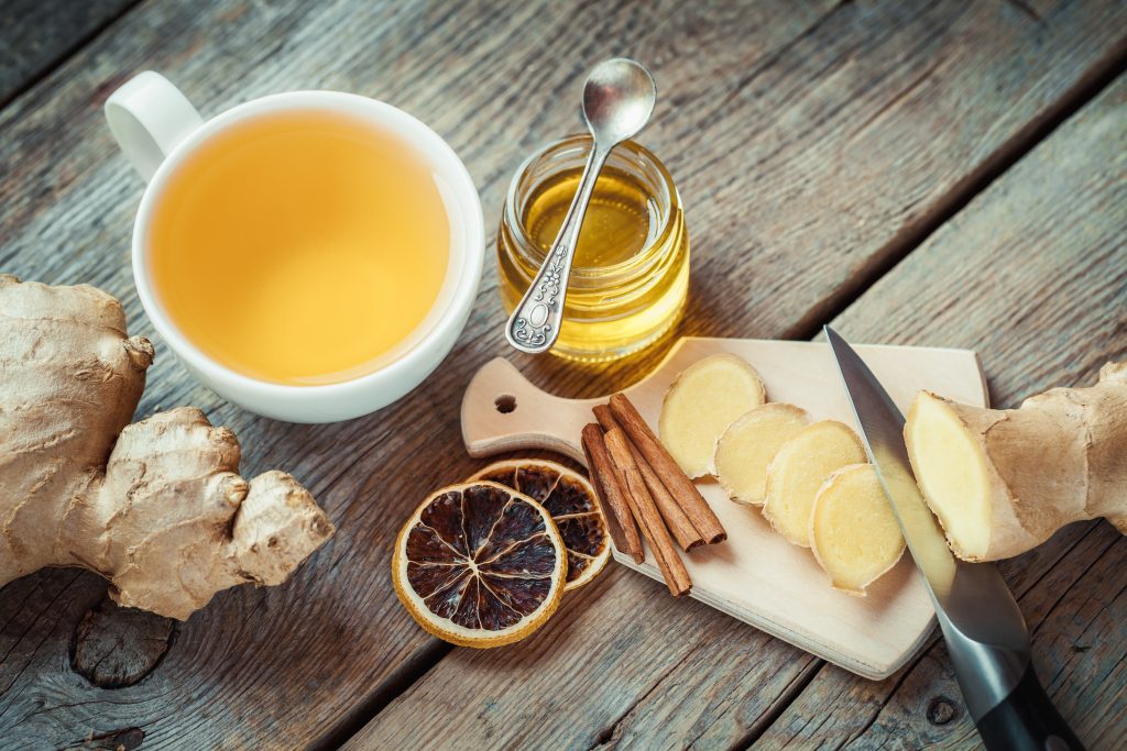 Mal de gorge et Ayurveda, tisane avec gingembre, miel, citron et cannelle sur une table en bois