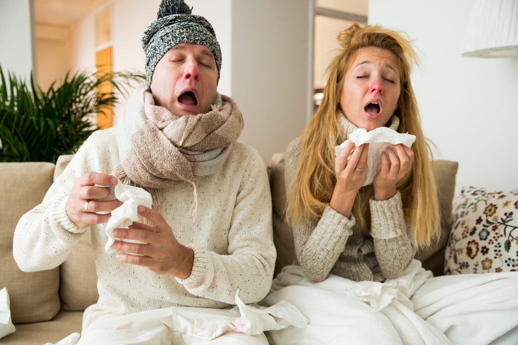 Ayurveda contre le rhume, un couple enrhumé éternuent et se mouchent